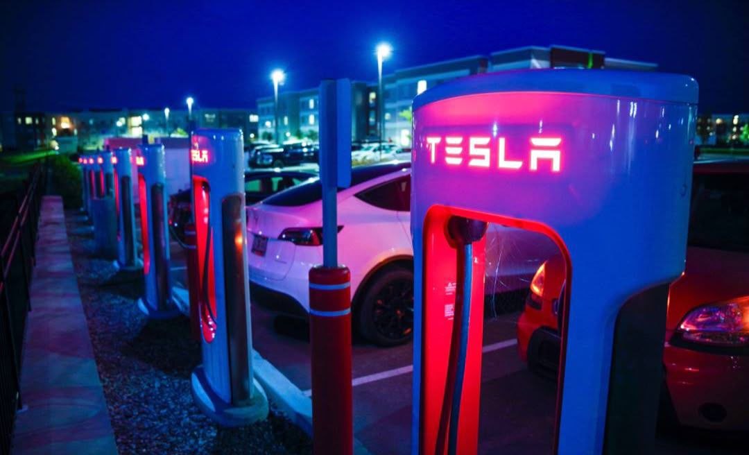 Tesla electric cars at a charging station at night
